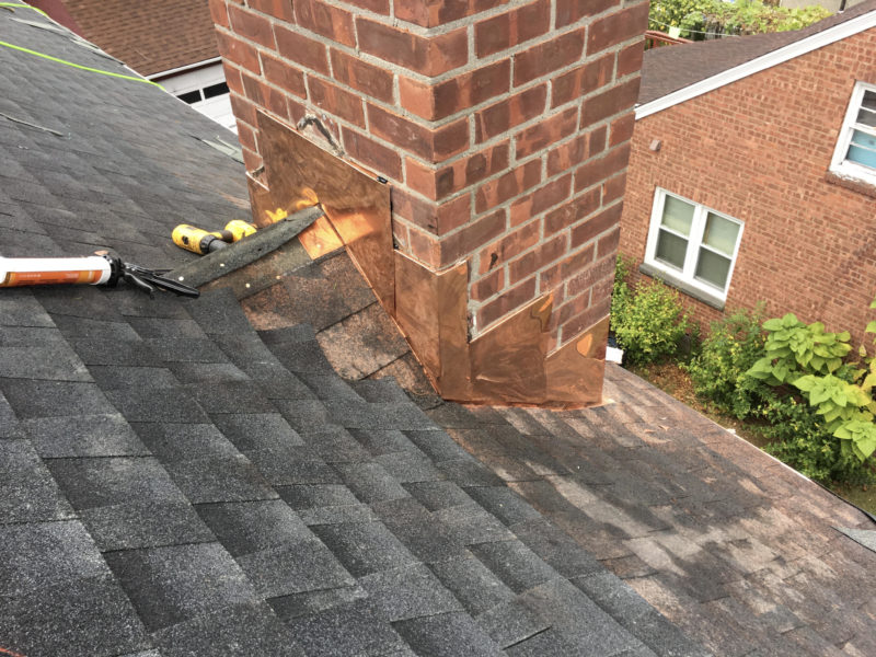 Shingle roof with a brick chimney.